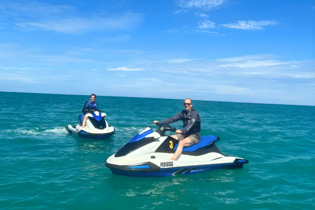 Two riders on jet skis in turquoise water off Isla Verde Beach, Puerto Rico