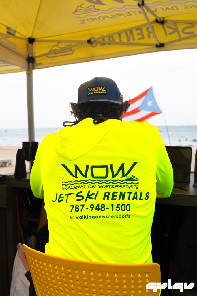 WOW staff member in a neon WOW shirt greeting riders at the Isla Verde rental stand